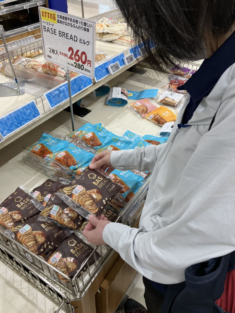 パン売り場で栄養強化パンを手に取る管理栄養士
