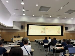 講演スライド「退院後の一日」を映した会場の様子