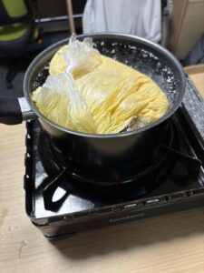 ポリ袋の中で膨らんだ蒸しパンを湯せん中｜災害時のパッククッキング