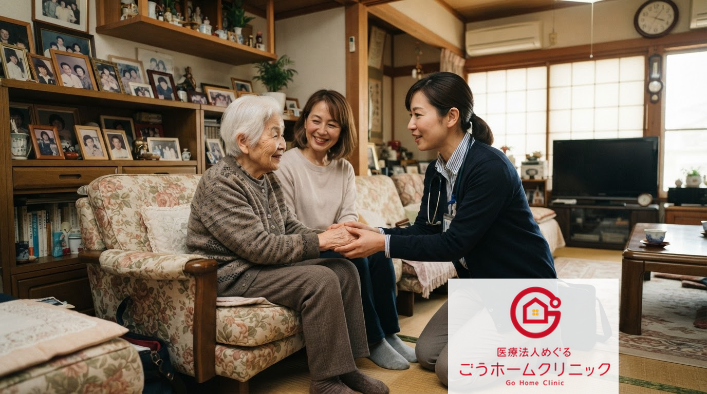 高齢女性が椅子に座り、医療スタッフ2名と手を握って笑顔で向き合っている。木製の家具と写真が飾られた温かみのある居間。